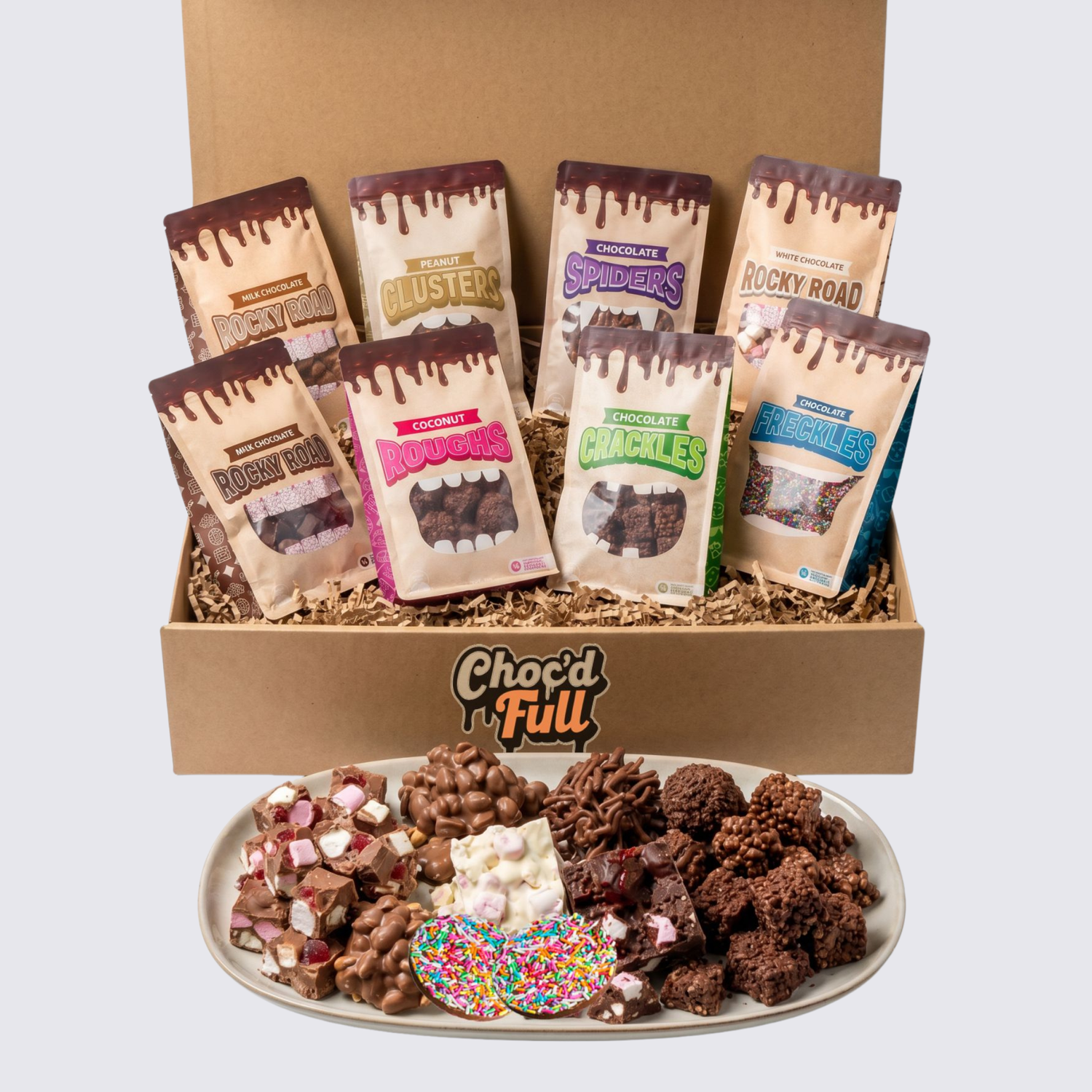 Box of Choc'd Full chocolate snacks with packaging and a plate of assorted snacks.