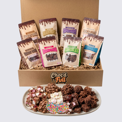 Box of Choc'd Full chocolate snacks with packaging and a plate of assorted snacks.